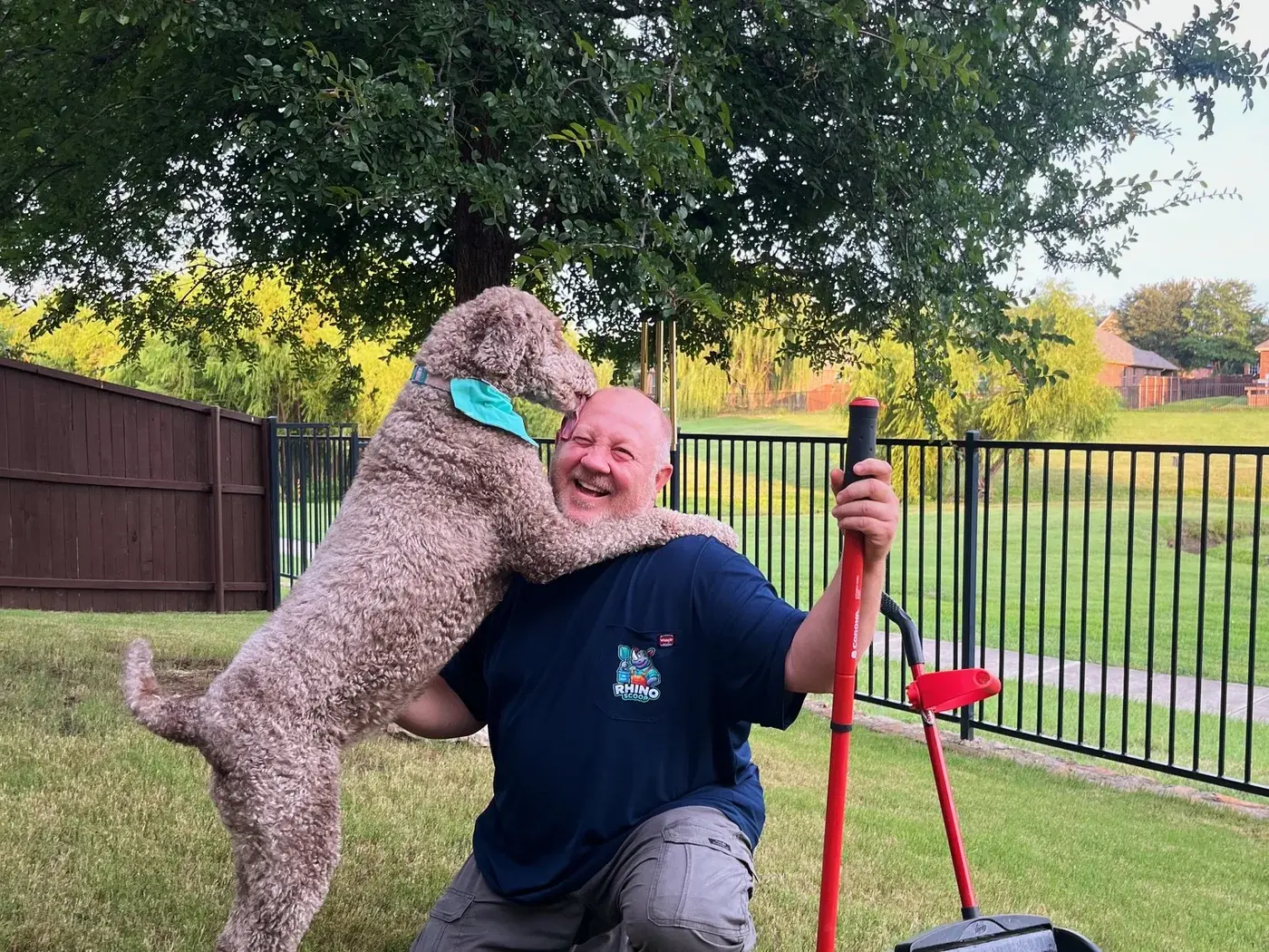 Rhino Scoop team members with a dog after a yard service visit