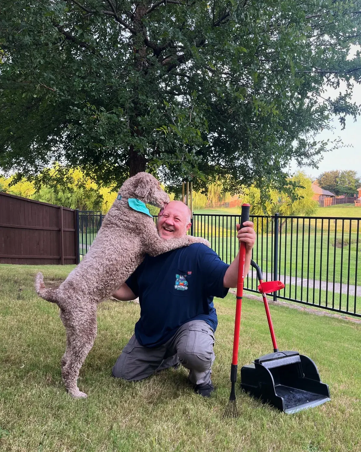 Rhino Scoop technician with a friendly dog in a North Texas yard